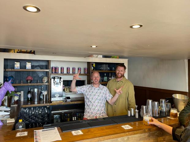 Two white males behind a wooden bar - 'The Winkle'